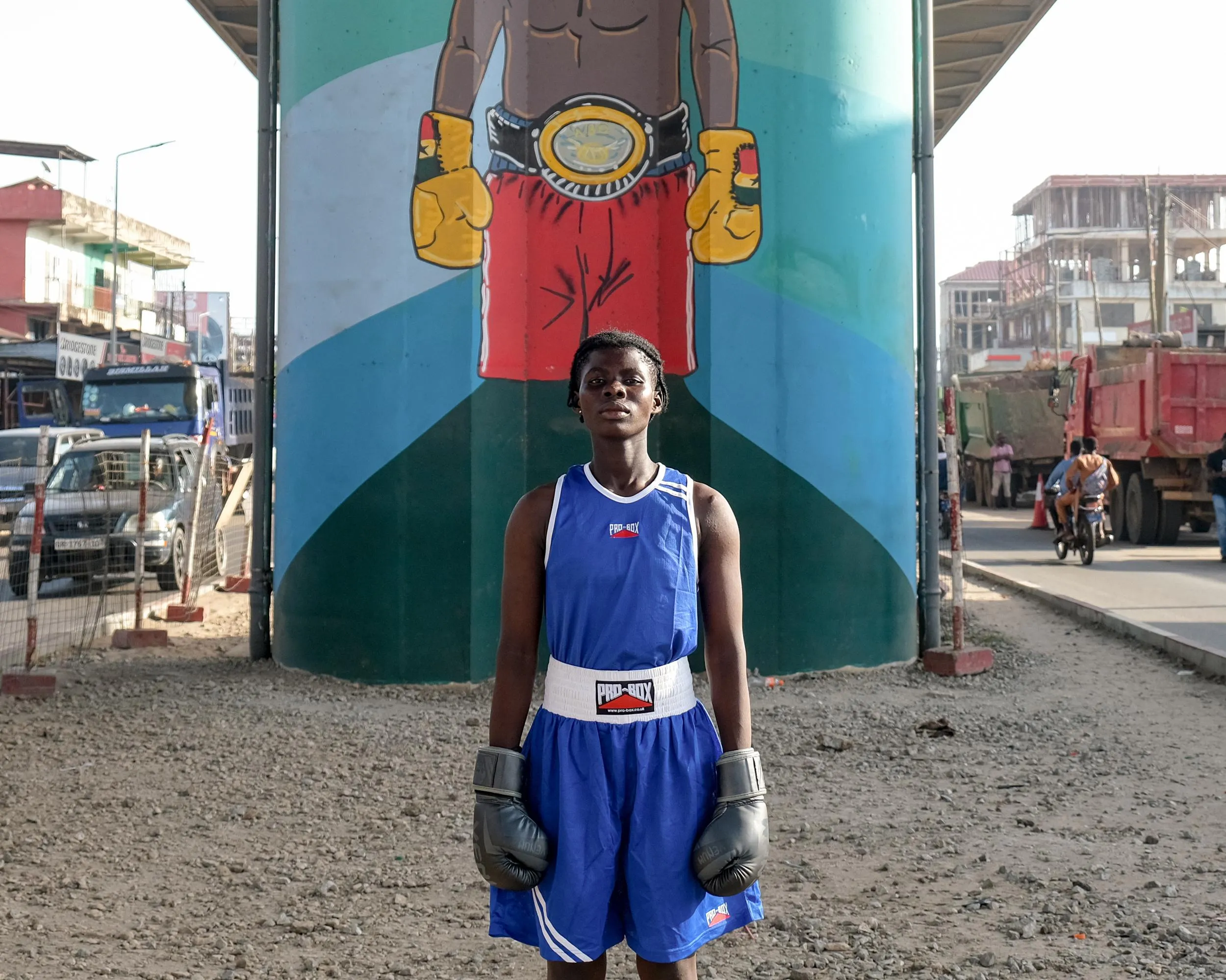 Ghanian amateur boxer Elizabeth Boakye takes a stand beneath a mural in the country’s capital, Accra.