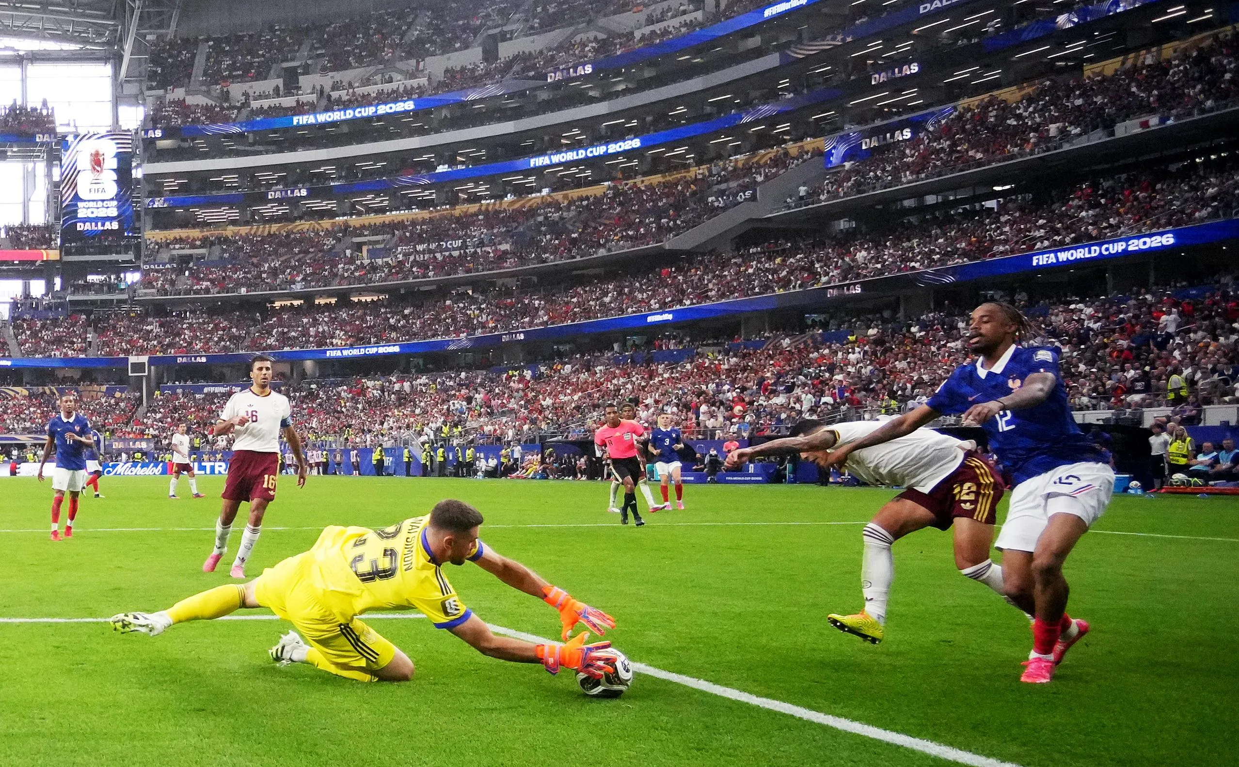 Spain's keeper Unai Simon claims the ball ahead of France's Bradley Barcola.