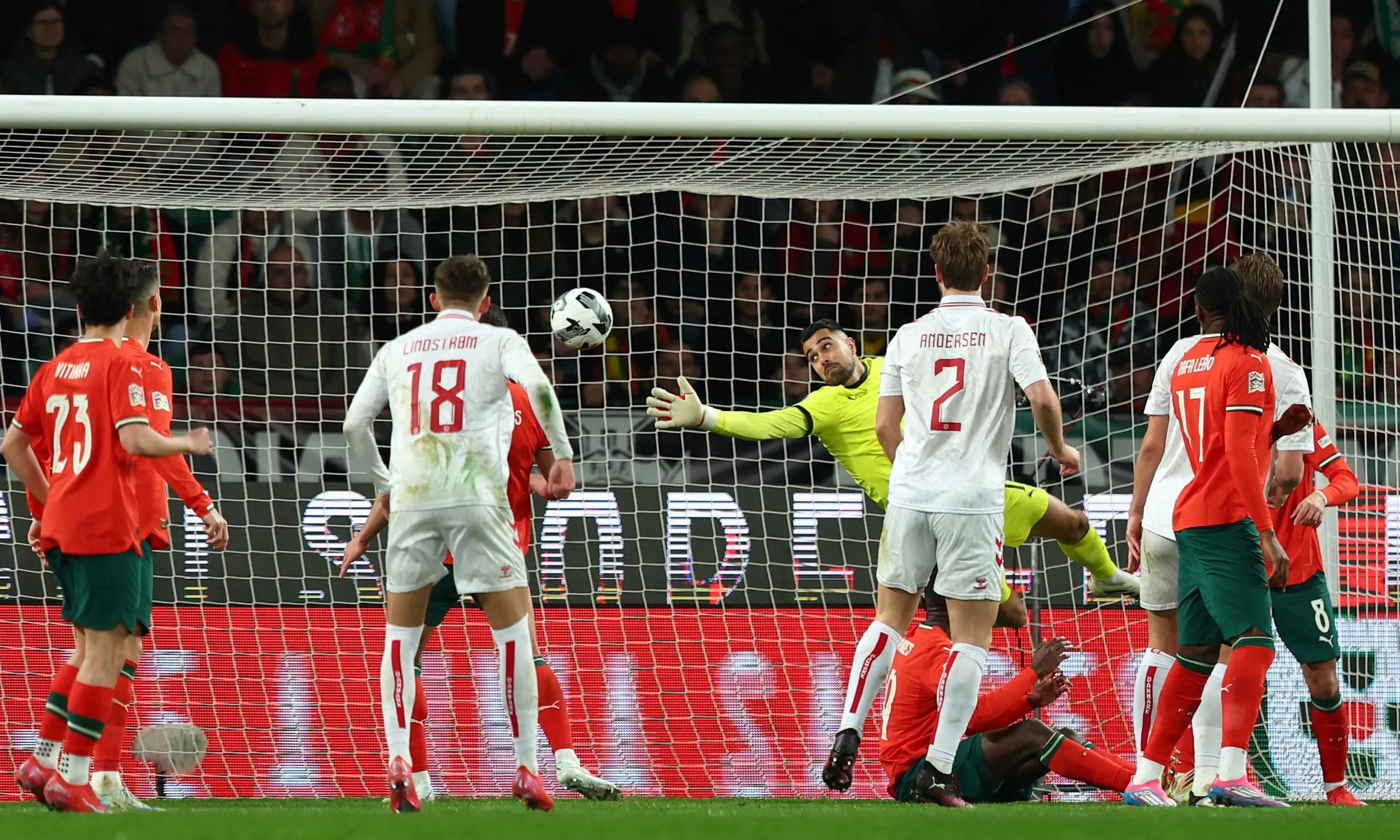 Portugal's Diogo Costa in action as Denmark's Rasmus Kristensen scores their first goal.