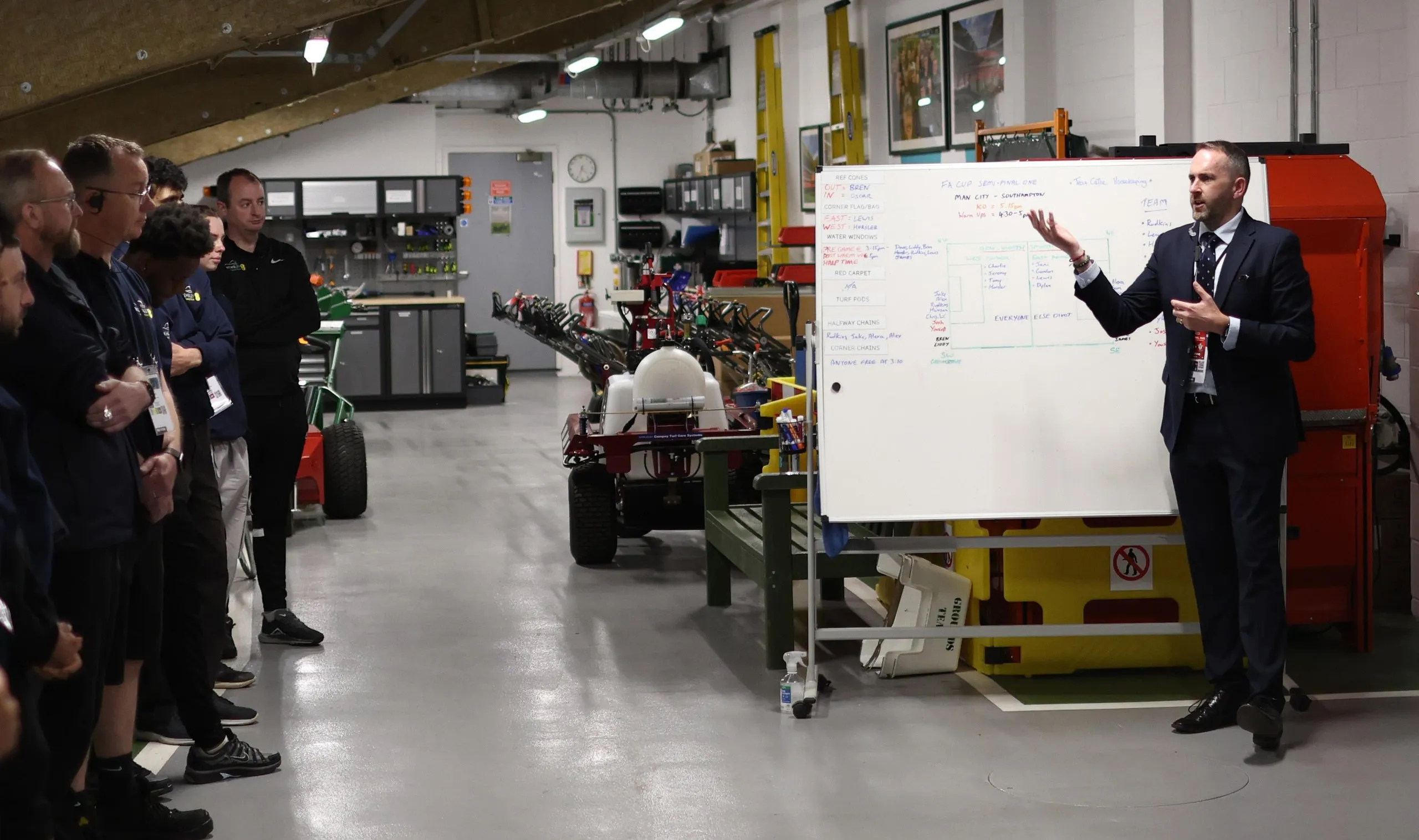 Karl Standley stands in front of a whiteboard briefing the team 