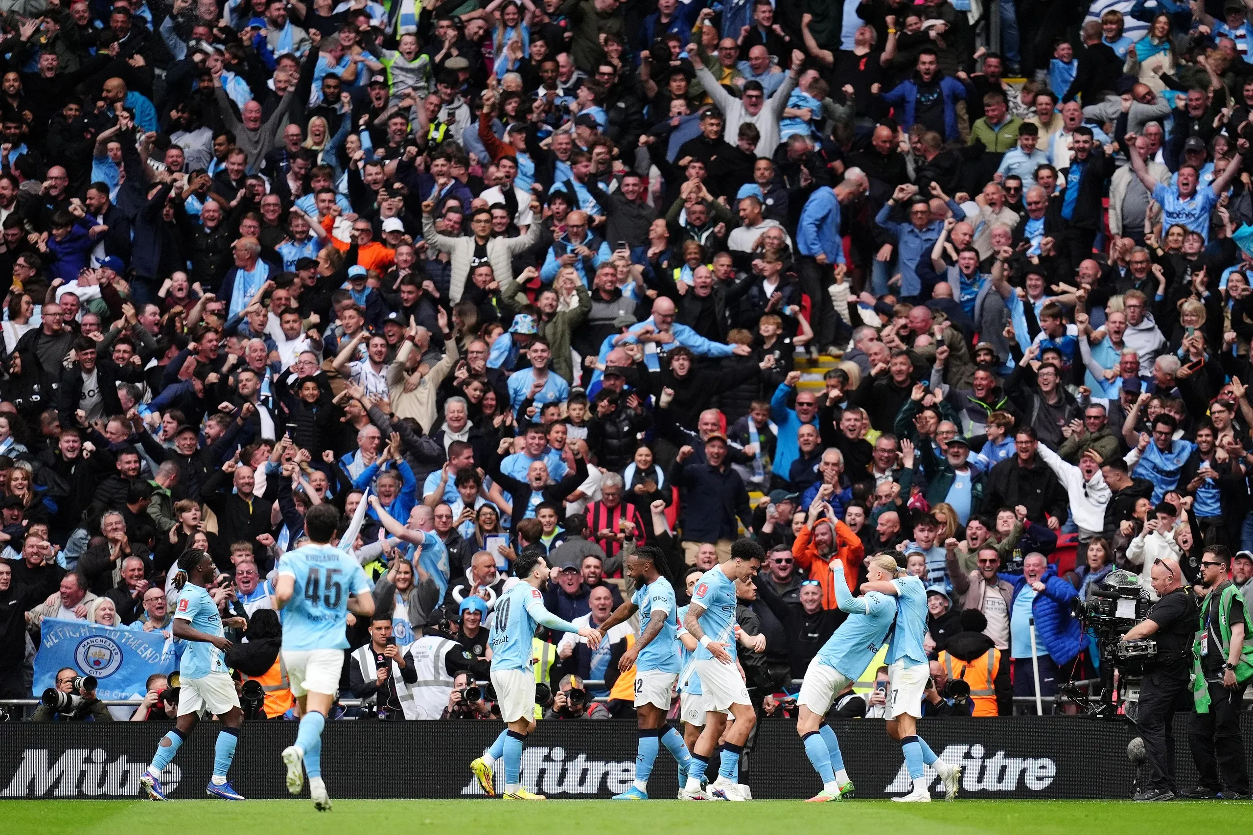 Manchester City's Antoine Semenyo (centre) celebrates scoring their side's first goal with Rayan Cherki (second left) Erling Haaland (second right) and teammates in front of the joyous City fans.