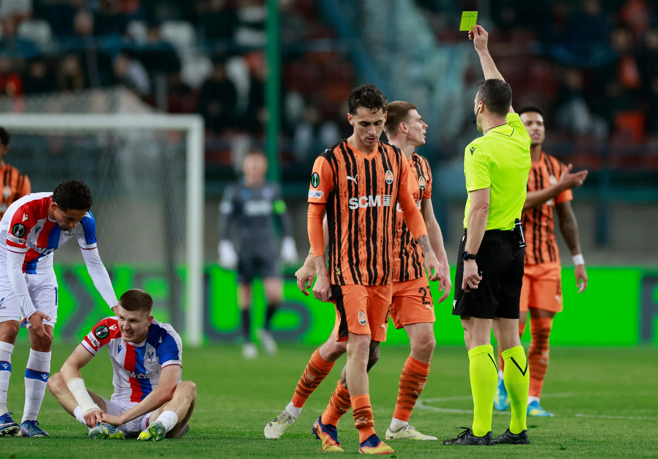 Referee Felix Zwayer shows a yellow card to Shakhtar Donetsk’s Oleg Ocheretko for a foul on Crystal Palace’s Adam Wharton (second left).