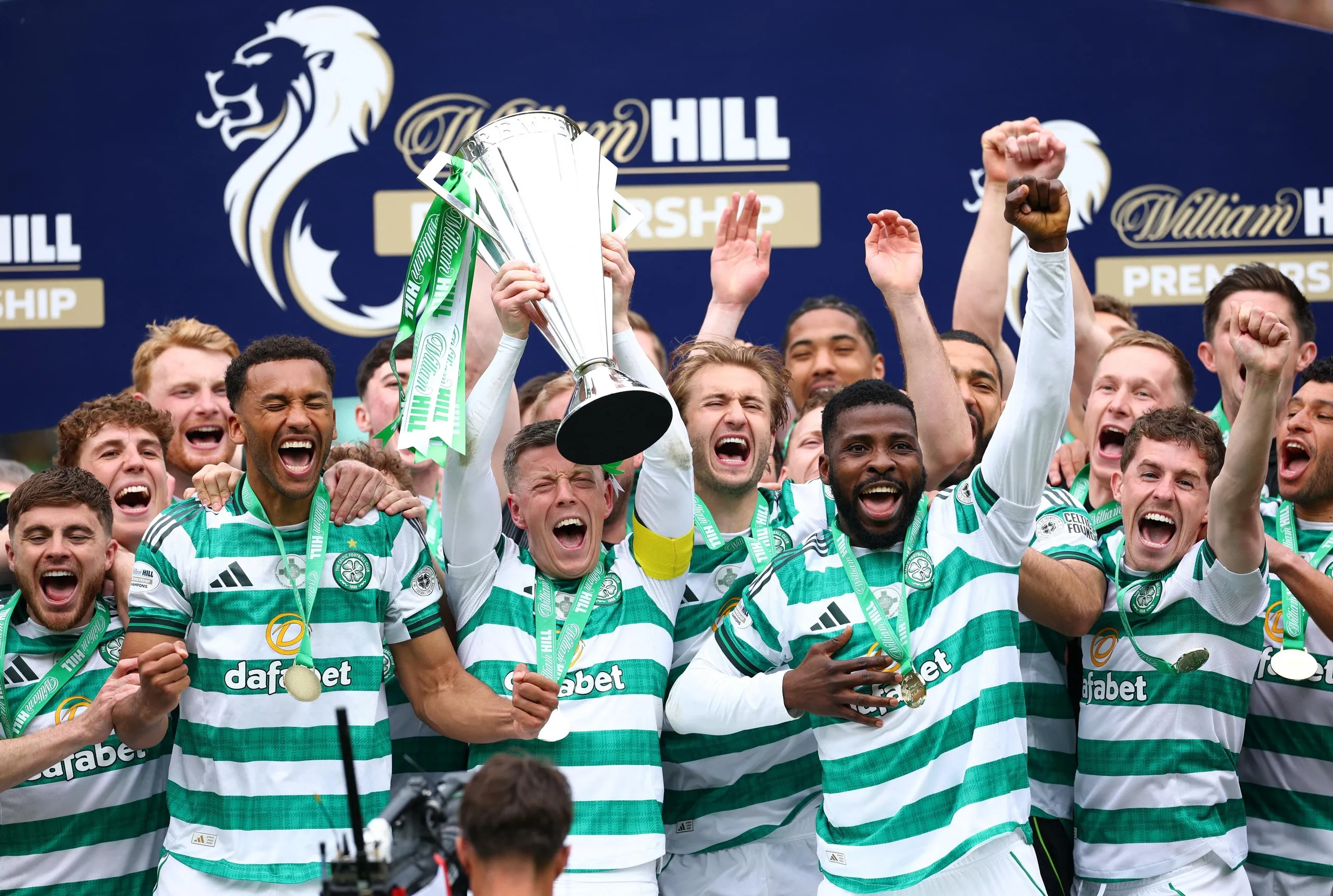 Celtic's Callum McGregor celebrates lifting the Scottish Premiership trophy with teammates.