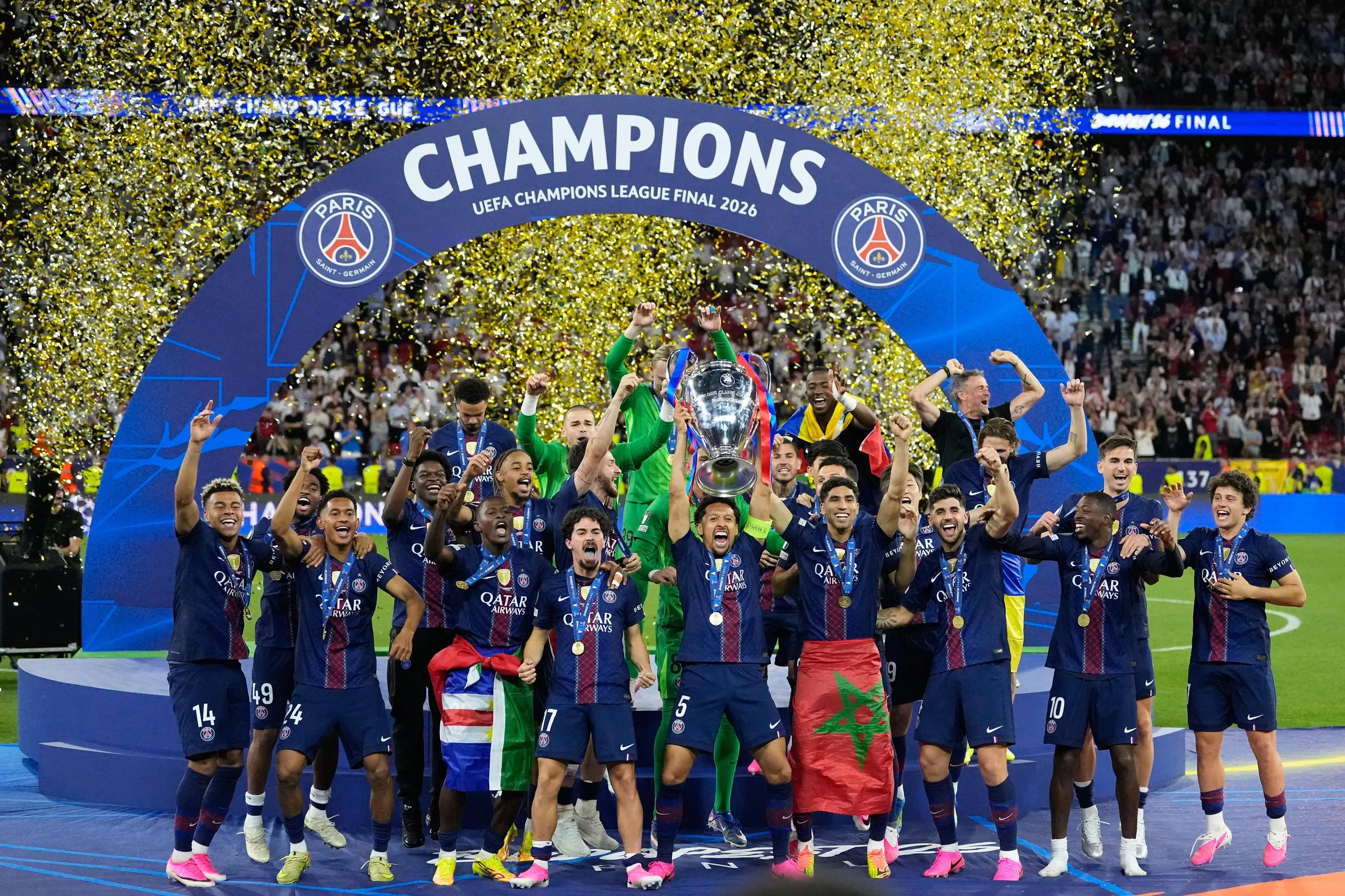 PSG's Marquinhos lifts the trophy as he and his teammates celebrate winning the Champions League final.