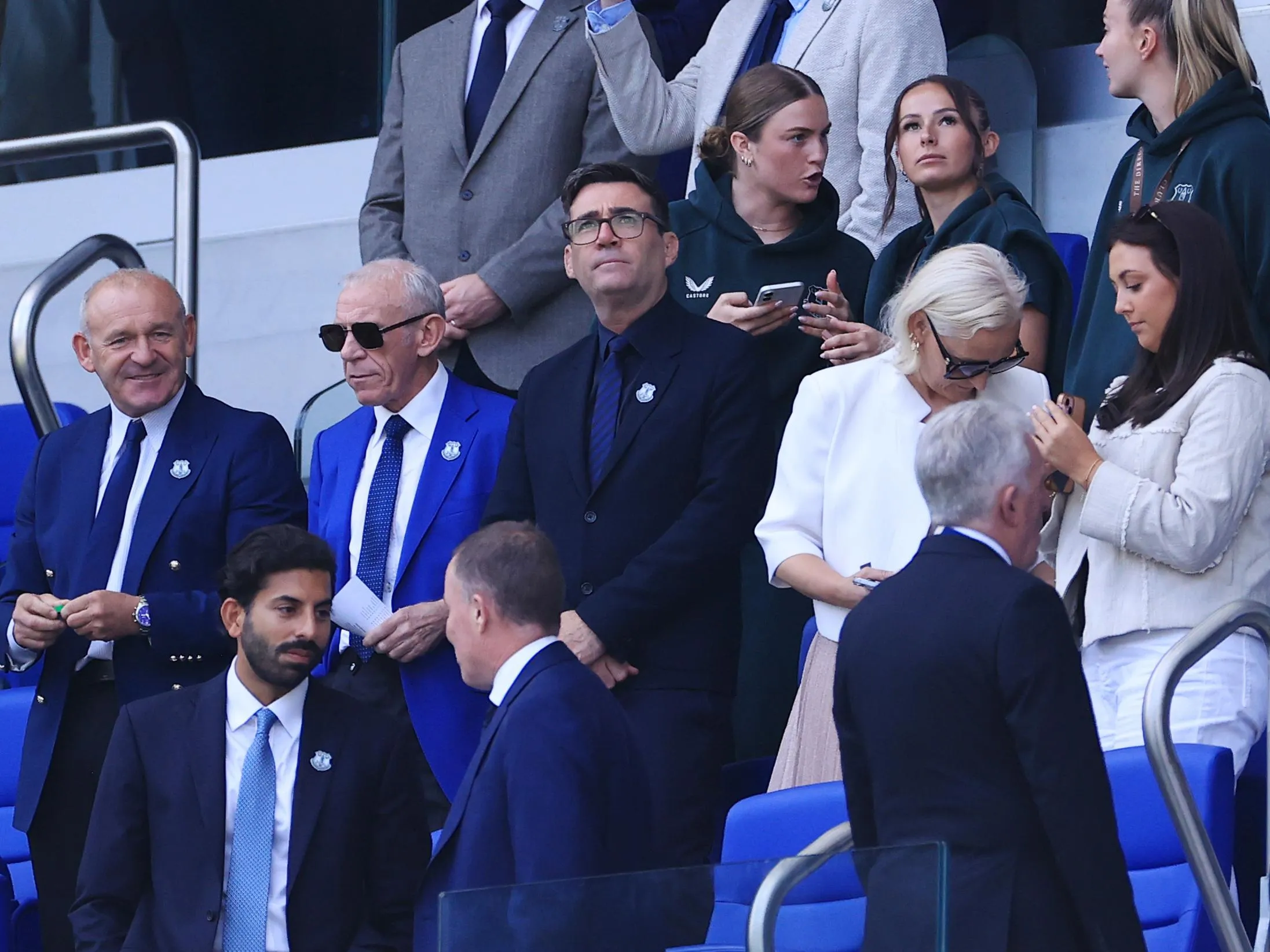 Andy Burnham in the stands wearing a dark suit ad Everton club badge at at Hill Dickinson Stadium