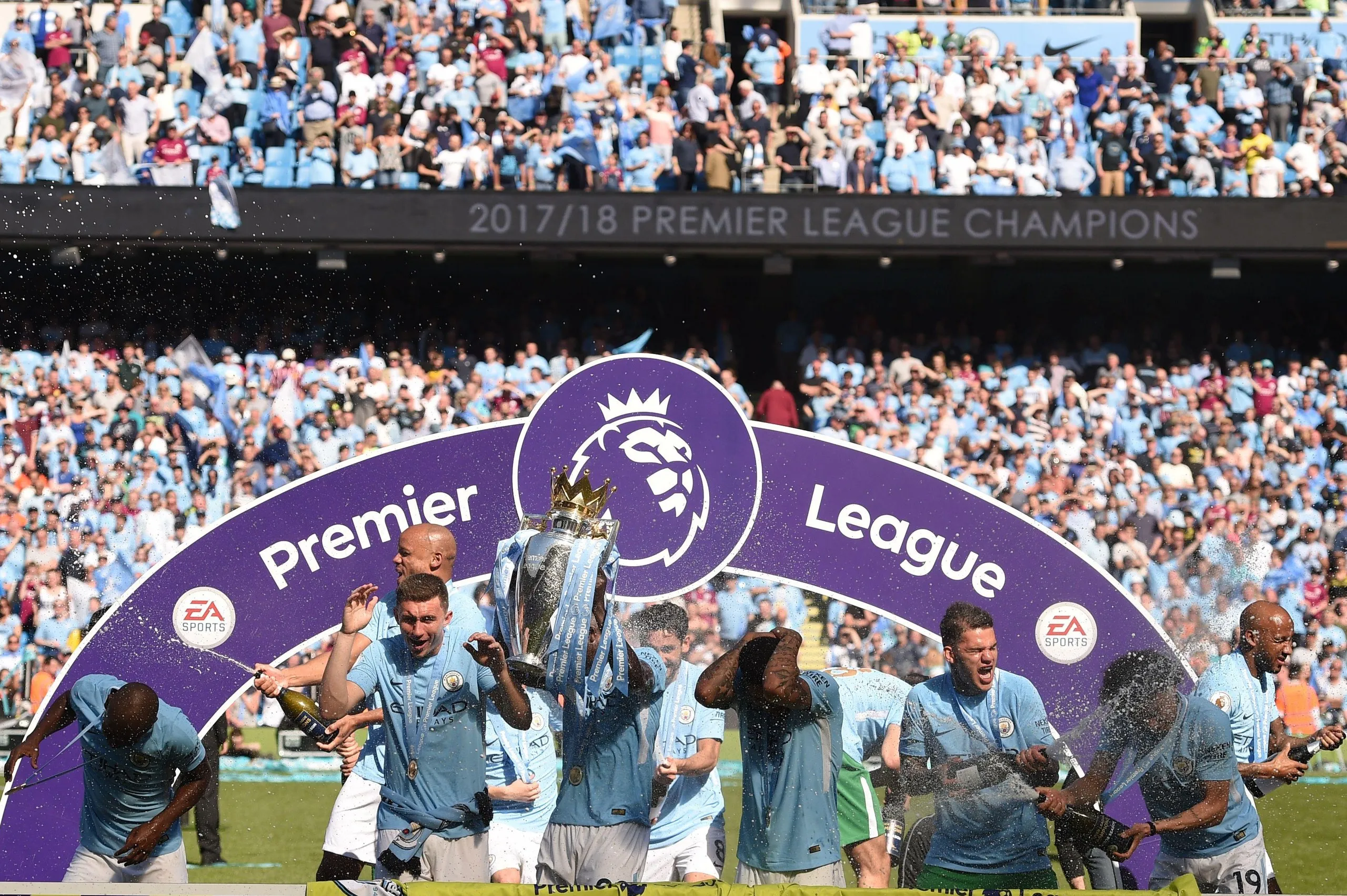 Manchester City players celebrate with the Premier League trophy on the Etihad Stadium’s pitch in May 2018.