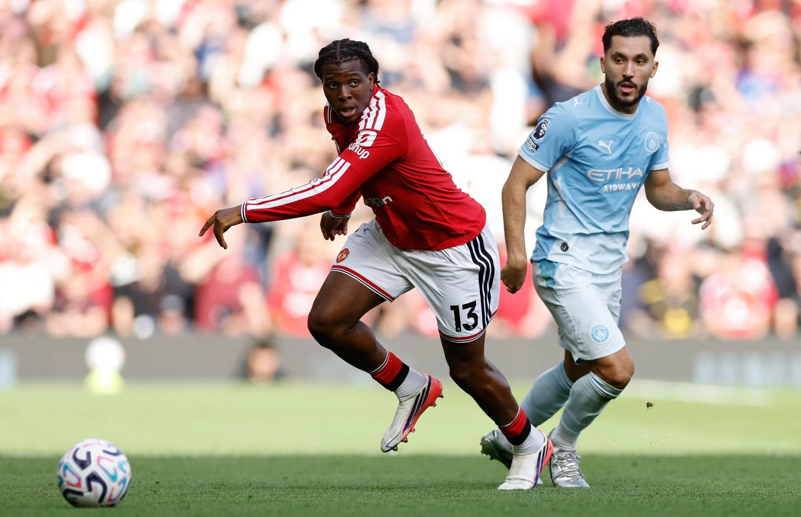 Patrick Dorgu prepares to kick the ball with Rayan Cherki behind