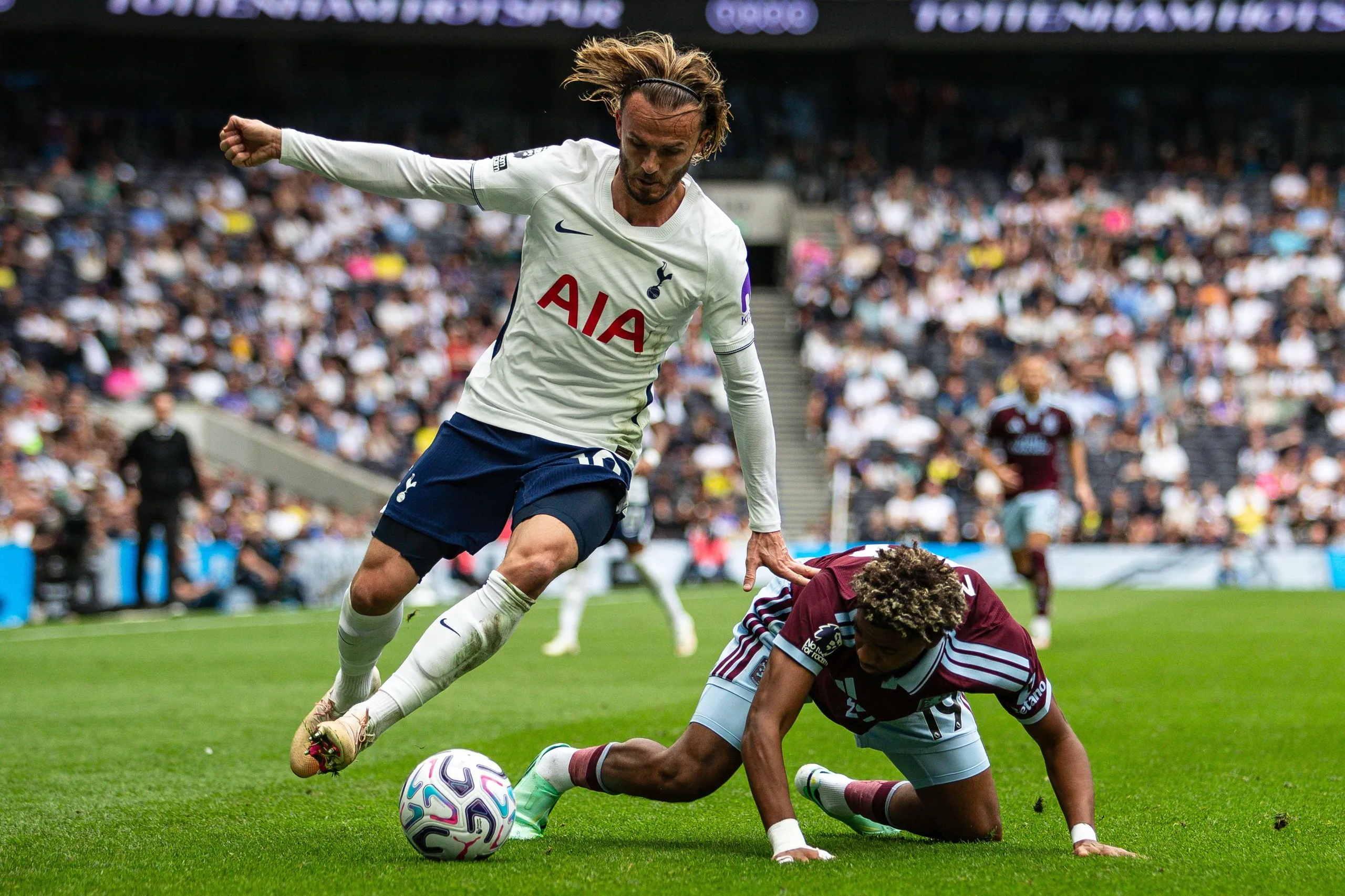Tottenham’s James Maddison rides an Aston Villa tackle,