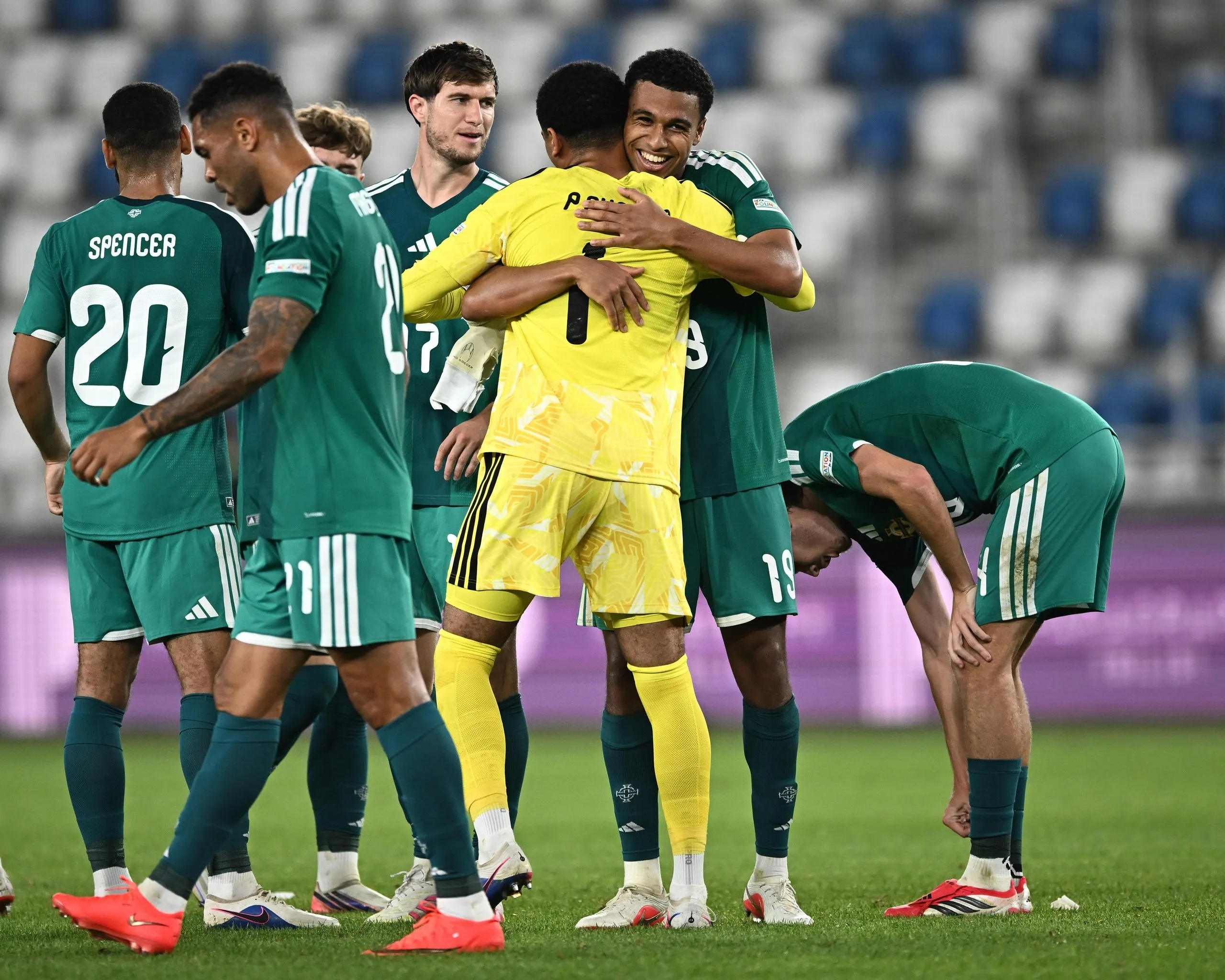 Shea Charles (centre, facing the camera) embraces his younger brother, the goalkeeper Pierce Charles, after Northern Ireland’s dramatic win in Georgia.