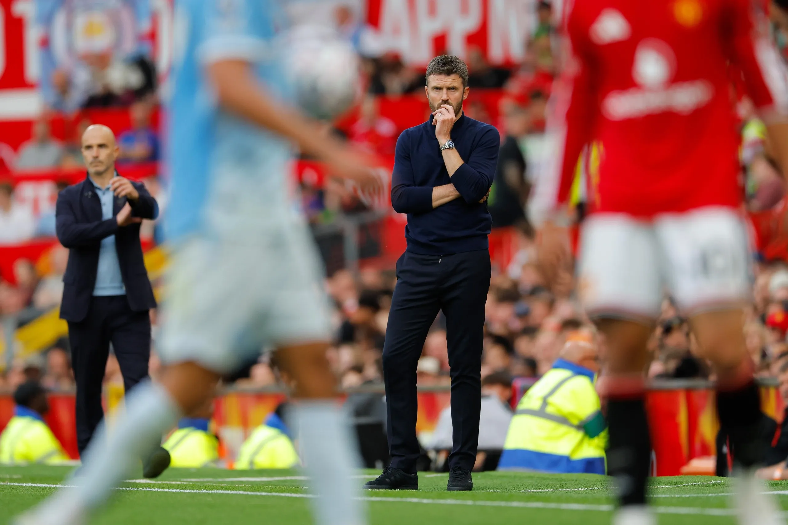 Michael Carrick watches from the technical area alongside Enzo Maresca with players in the foreground