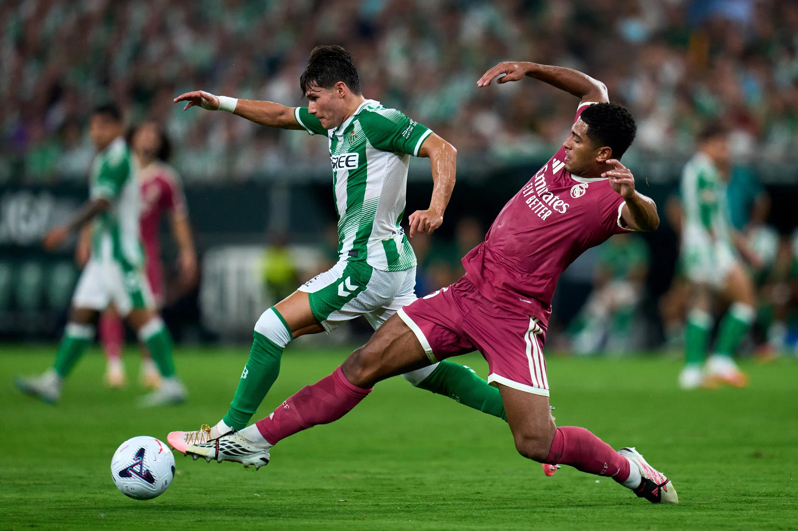 Fran García tries to beat Jude Bellingham to the ball while playing for Real Betis against Real Madrid.