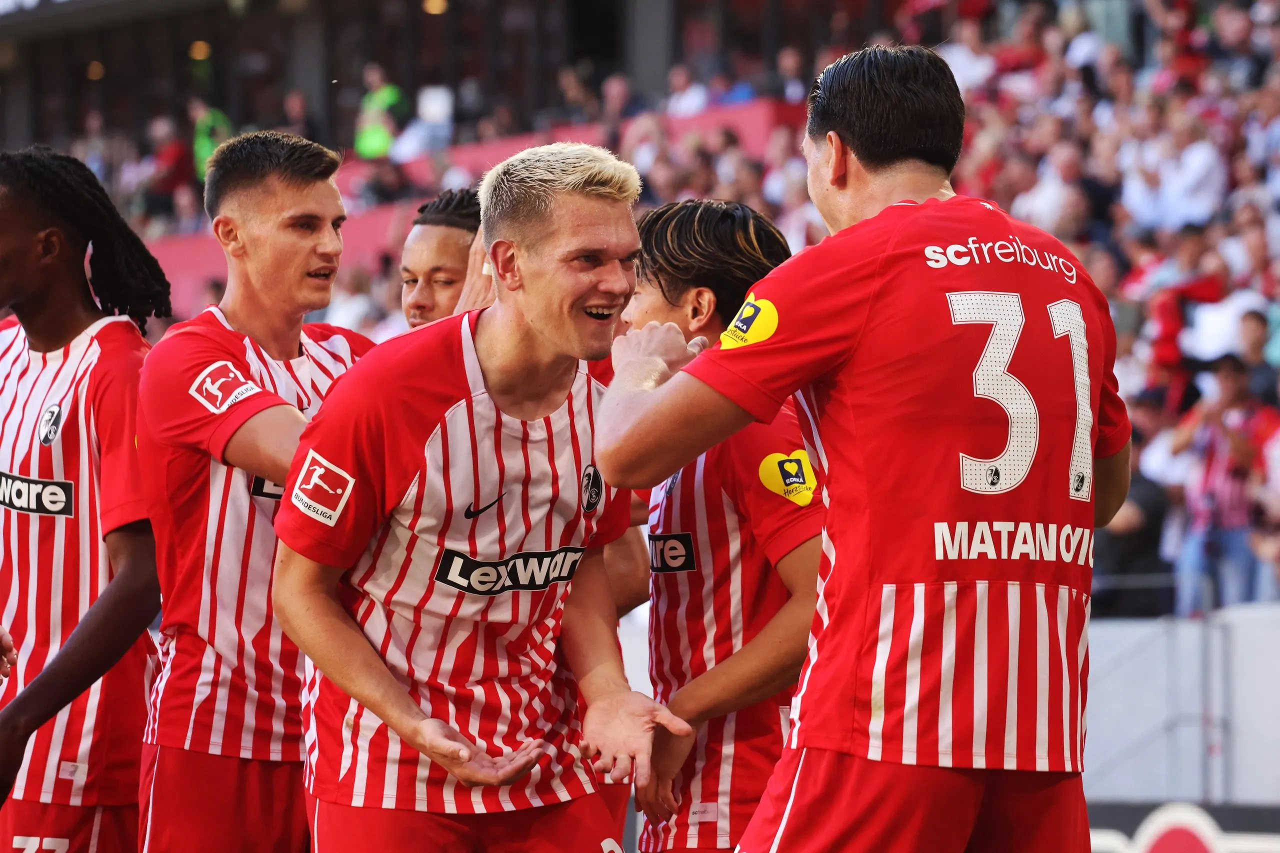 Freiburg's Matthias Ginter congratulates Igor Matanovic on the opening goal against Borussia Mönchengladbach.