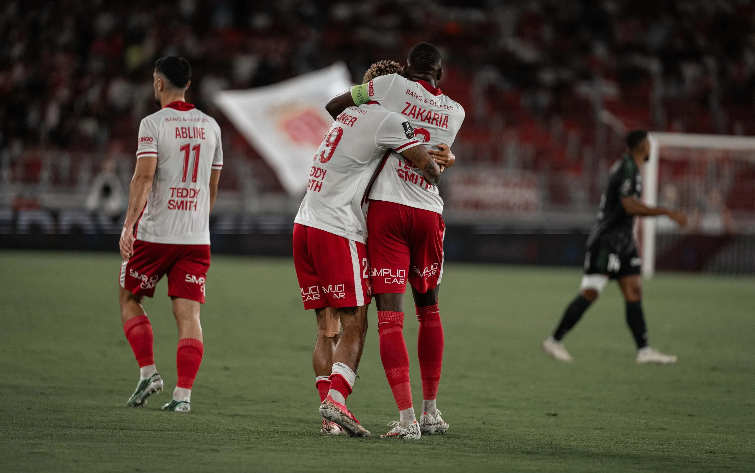 Paris Brunner and Denis Zakaria embrace after Monaco take the lead in their win against Lens