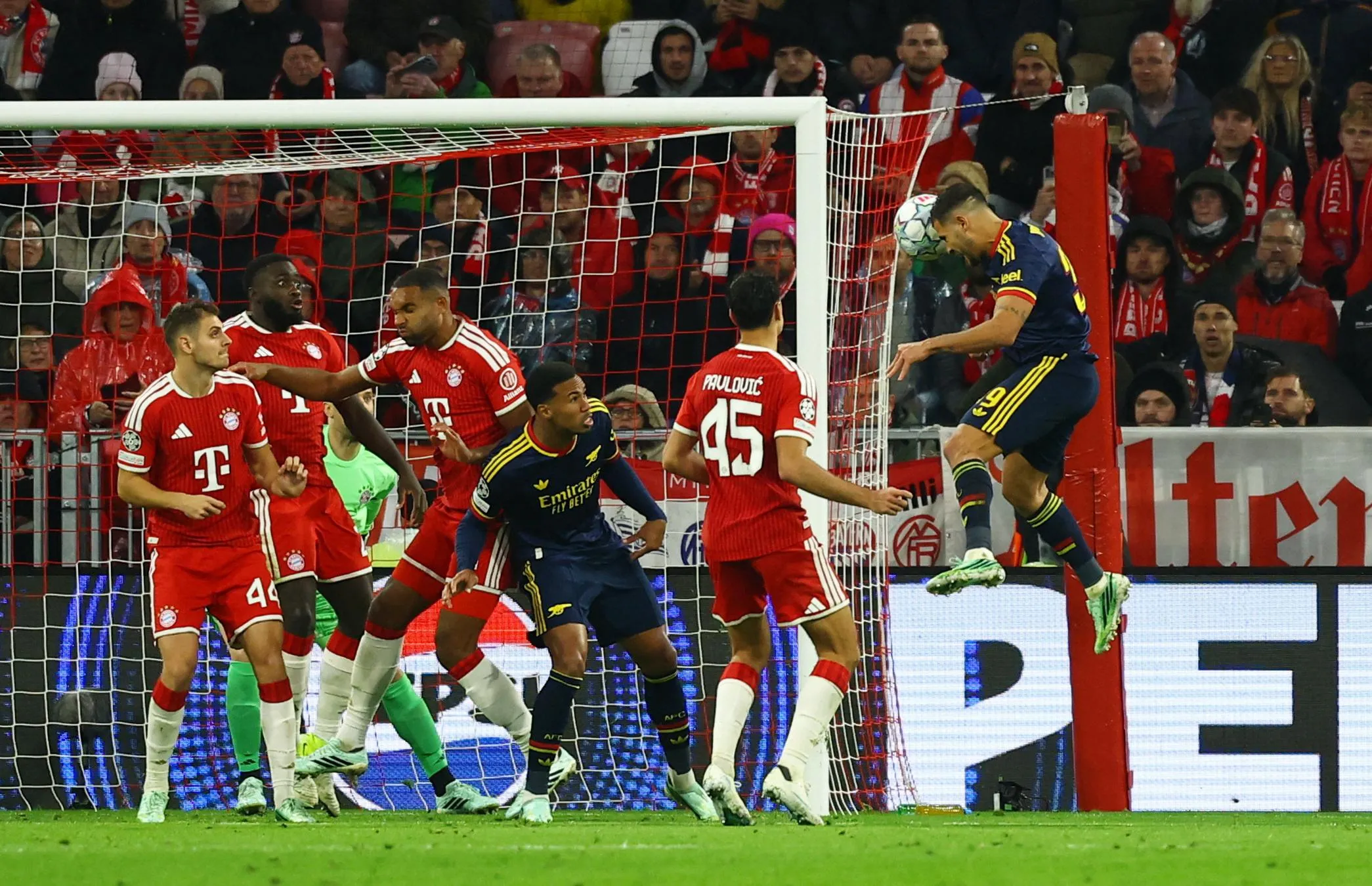 Arsenal’s Bruno Guimaraes leaps to head the ball above Bayern Munich defenders near the goal