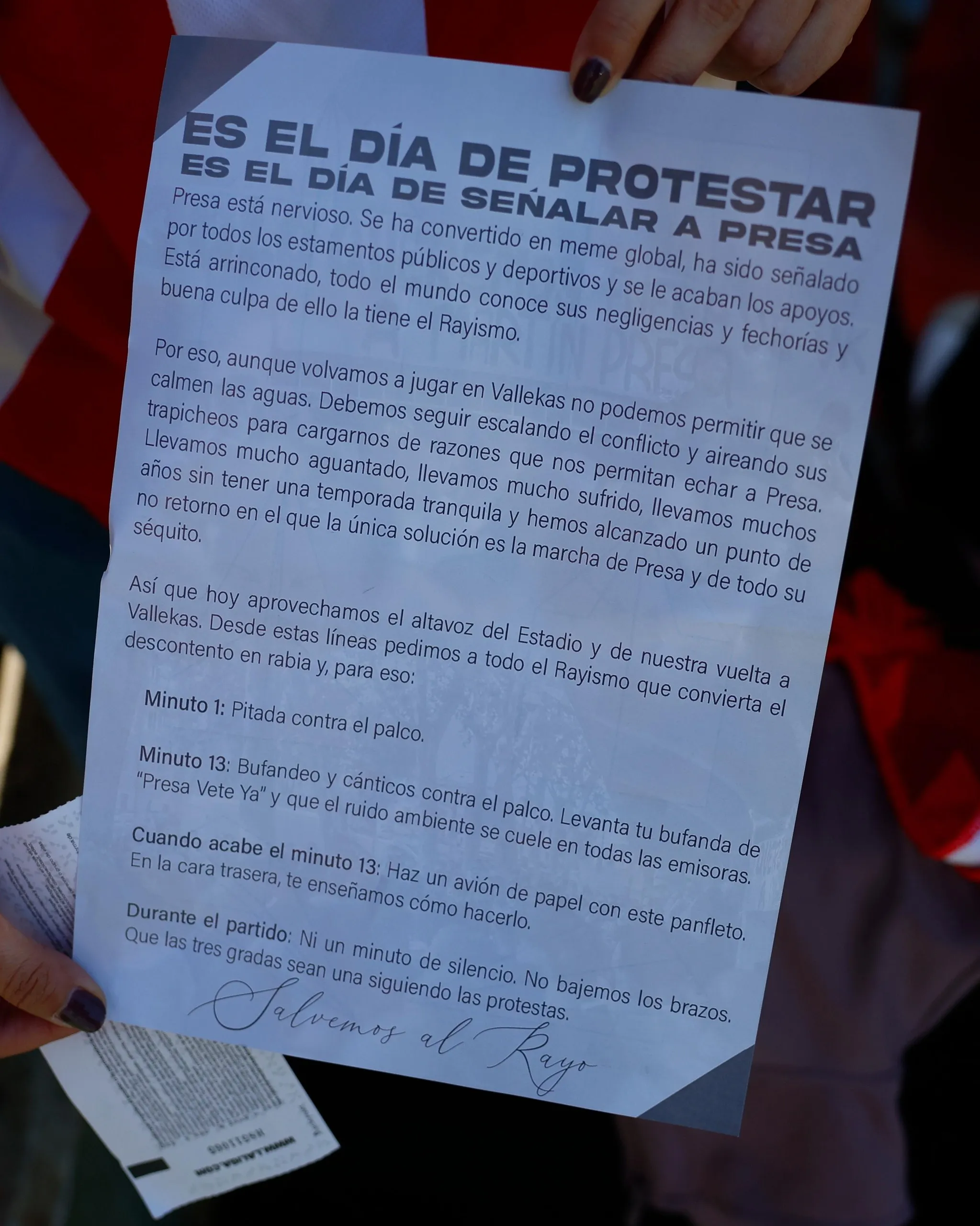 A Rayo Vallecano fan shows the protest flyer against their club’s chair