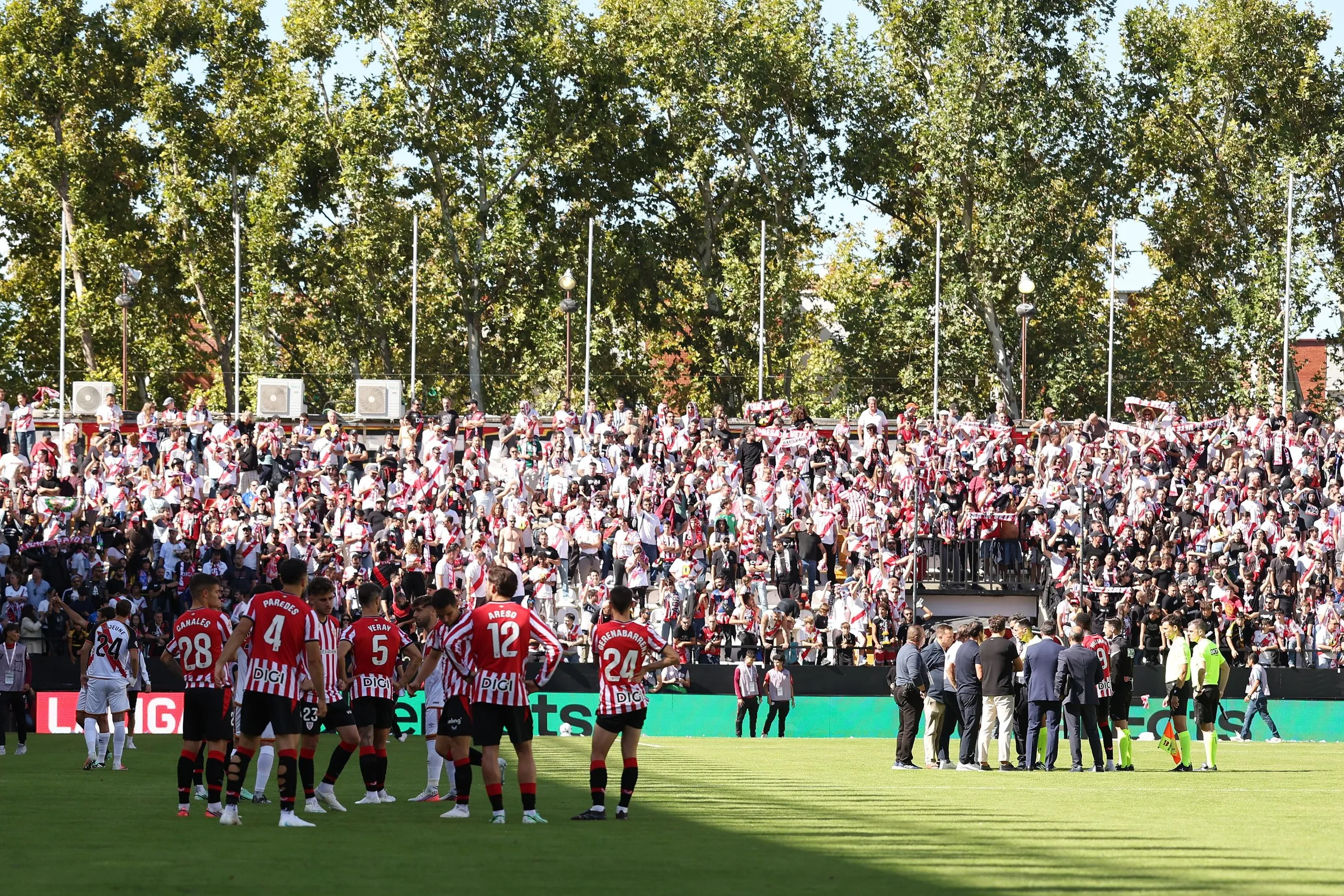 Athletic Club players wait on the pitch (left) as the referee makes the decision to abandon the La Liga match between Rayo Vallecano and Athletic Club (right). 