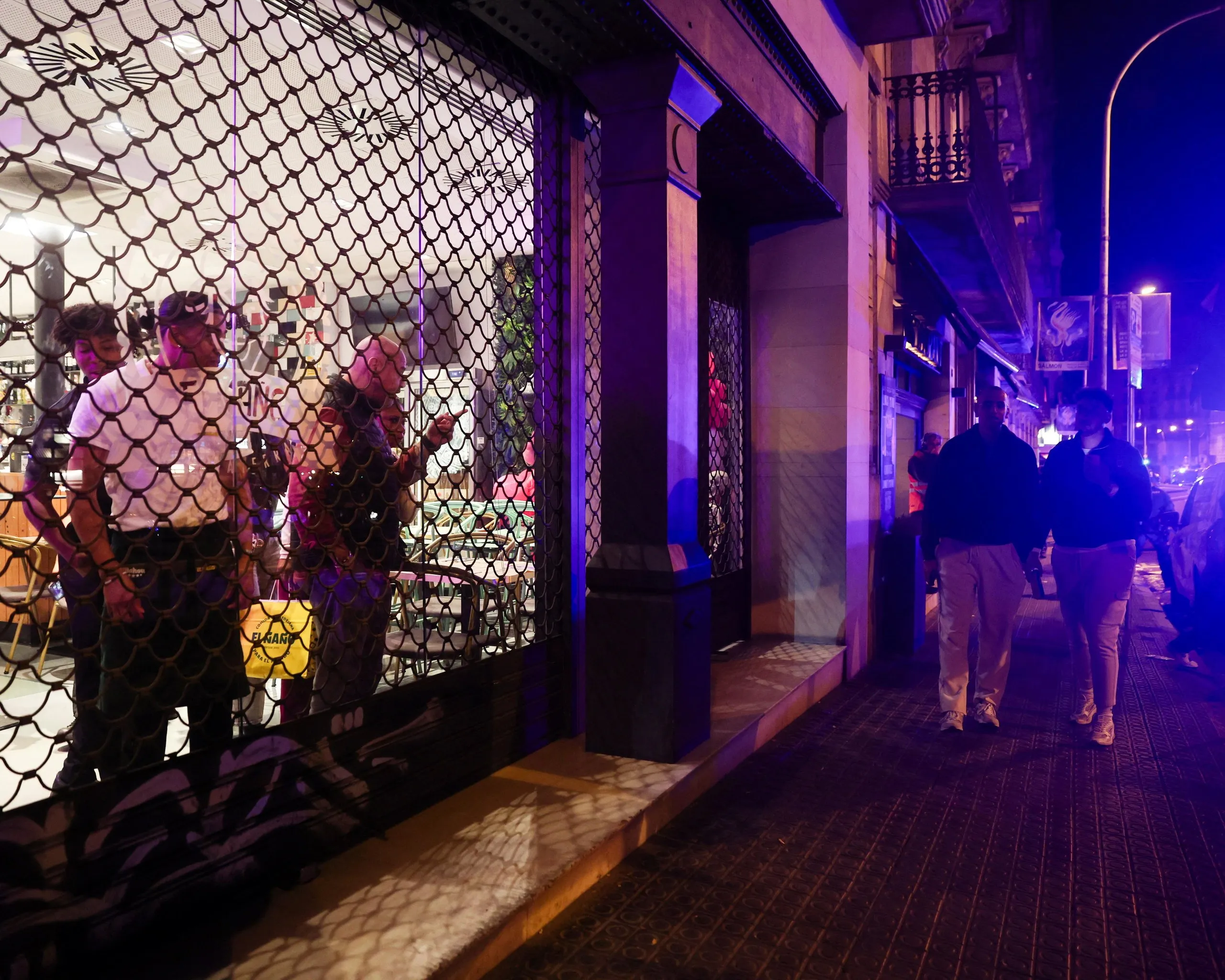 People look out from inside a shuttered store amid damage and disorder in Barcelona on Saturday.