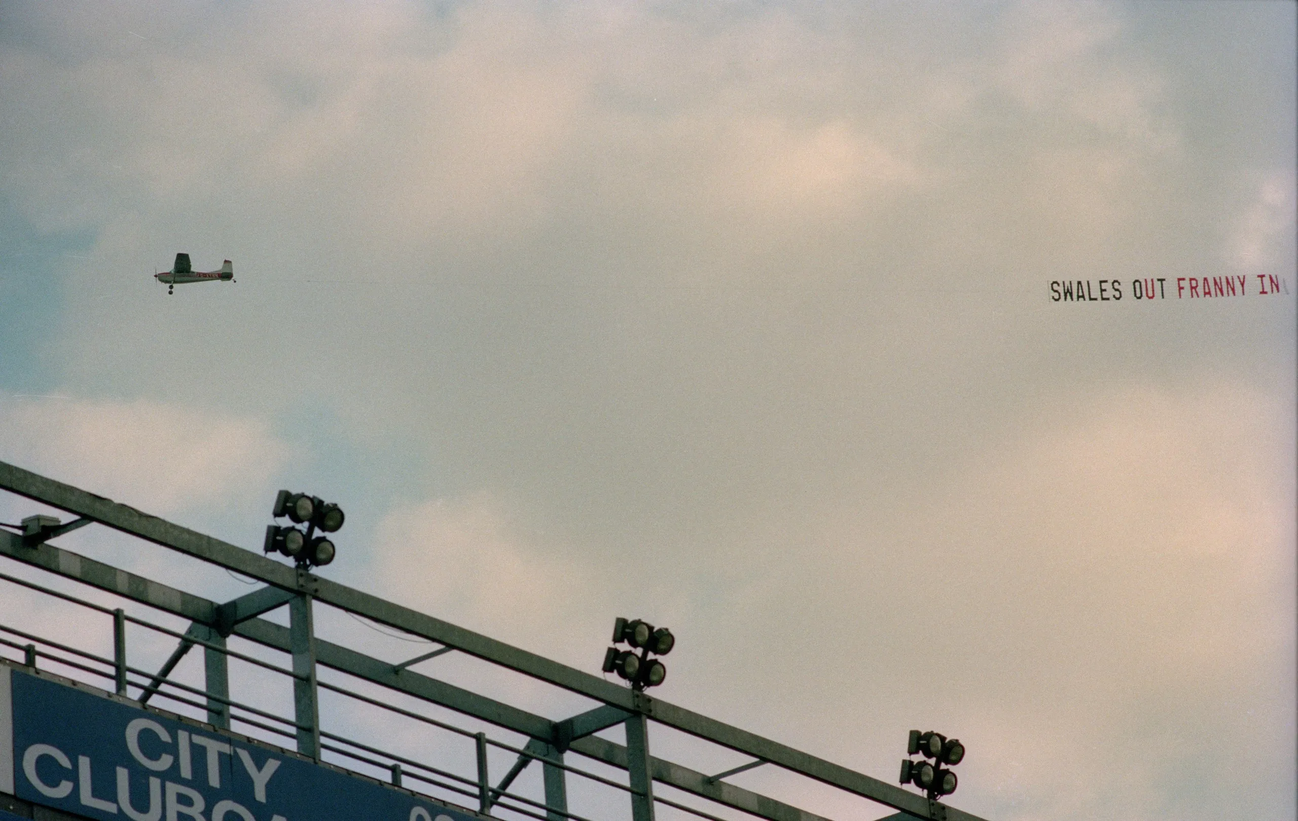 An aeroplane flies over Maine Road during a game v Liverpool with a banner urging for chair Peter Swales to leave and be replaced by Francis Lee, October 1993.