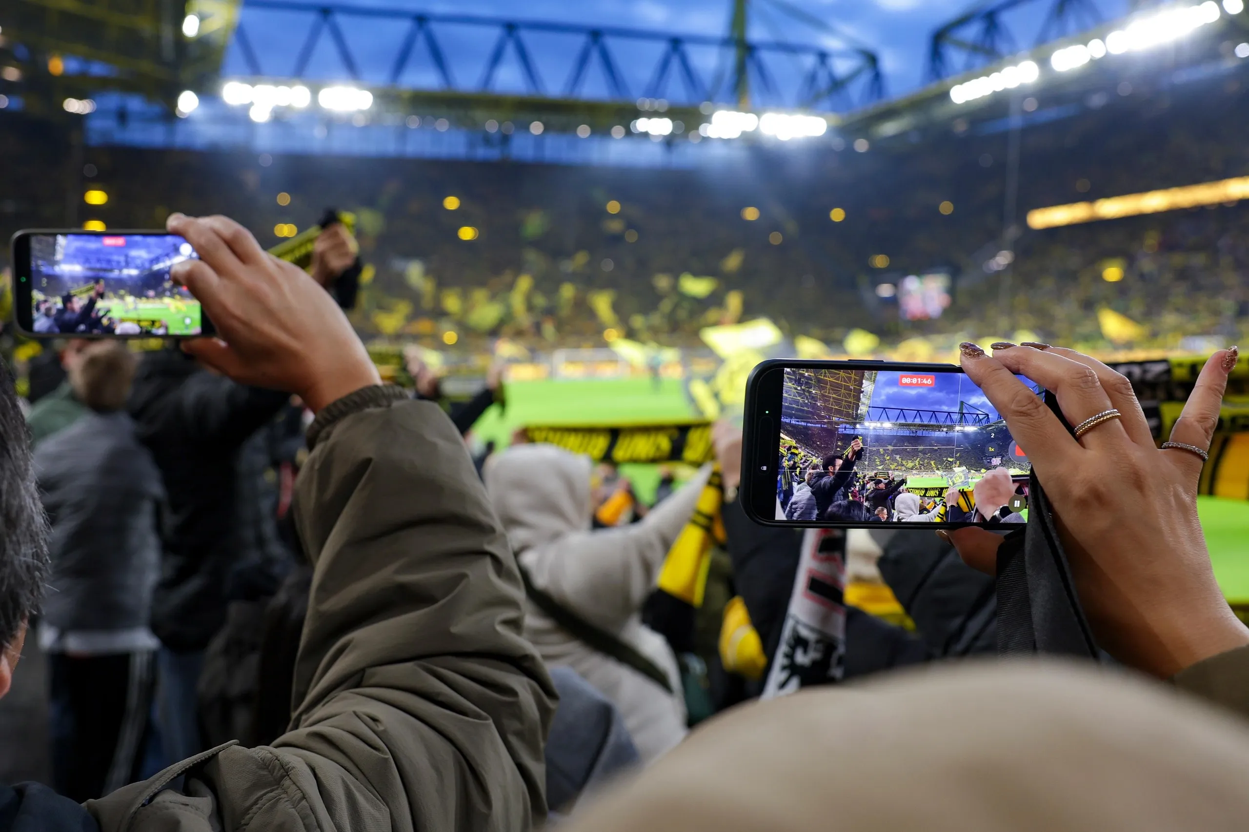 An image of fans holding smartphones to take pictures of Dortmund’s stadium before a match